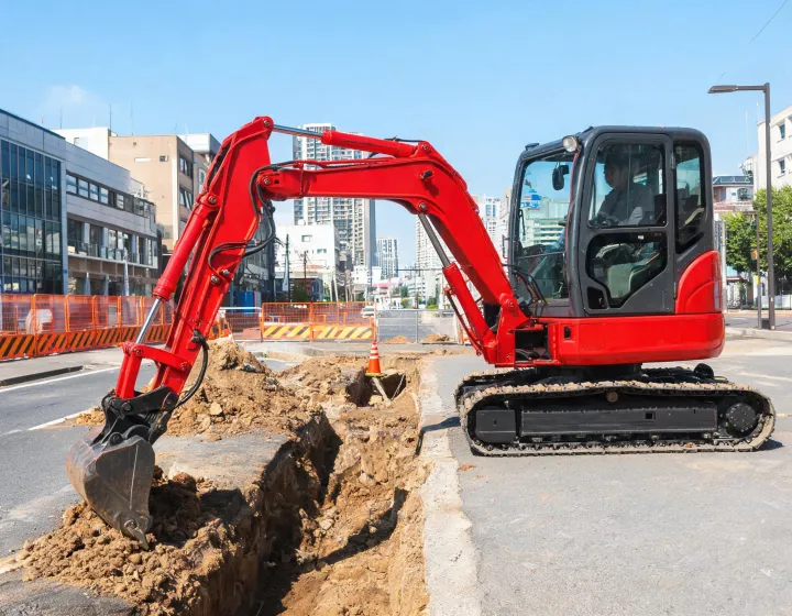 Yanmar mini excavator digging urban utility trench